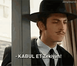a man wearing a hat and tie says kabul et zekiyim