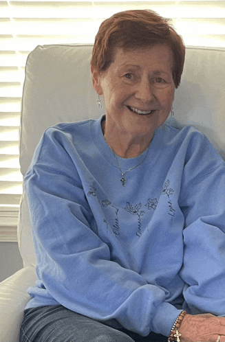 an elderly woman wearing a blue sweatshirt with the name ellen written on it