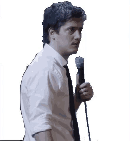 a man in a white shirt and tie is holding a microphone in his hand
