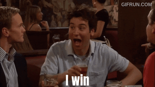 a man sitting at a table with a glass of beer and says i win