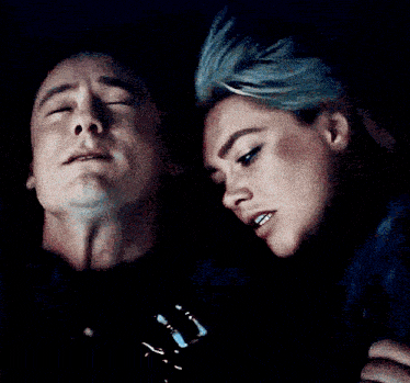 a man and woman are looking at each other in the dark