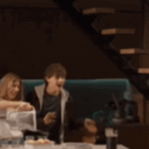 a blurry picture of people sitting at a table in a dark room