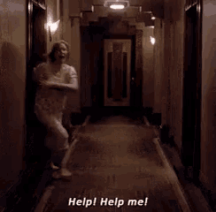 a woman in a white dress is running down a hallway and saying help help me .