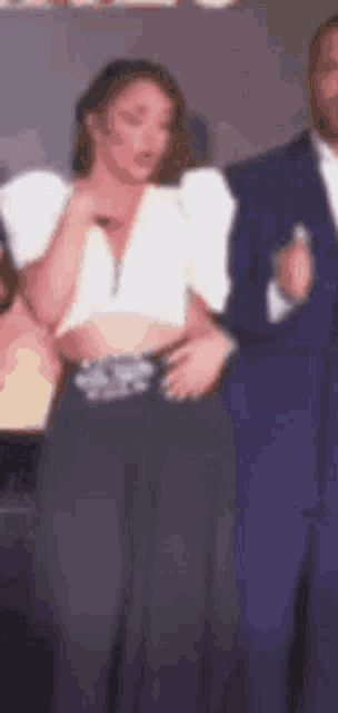 a blurry picture of a woman standing next to a man in a suit .