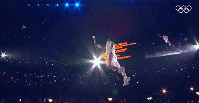 a man is jumping in the air with a sign that says " achtung "
