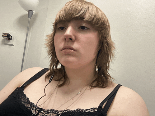 a woman wearing headphones and a black lace bra