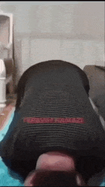 a man is laying on his stomach on a blue blanket with his head on another man 's face .