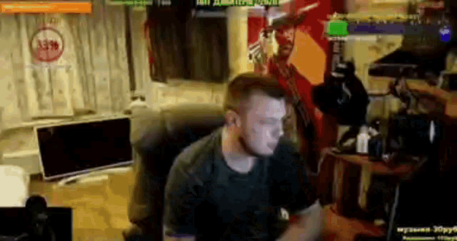 a man is sitting in a chair in front of a computer in a living room .
