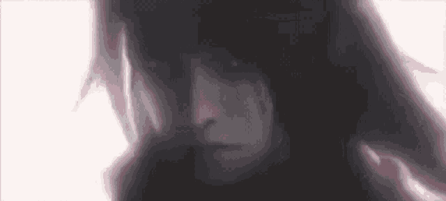 a close up of a person 's face with long black hair and a red jacket .