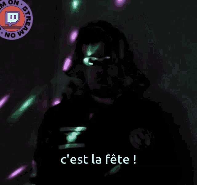 a man wearing headphones says c'est la fête in a dark room