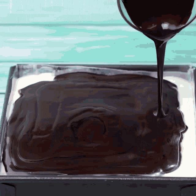 chocolate is being poured on top of a cake