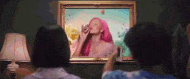 two people are looking at a framed picture of a woman with pink hair