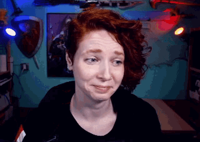 a woman with red hair making a sad face