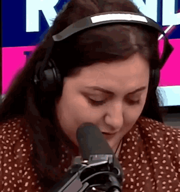 a woman wearing headphones is talking into a microphone