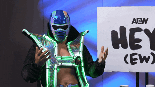 a wrestler stands in front of a sign that says hey crew