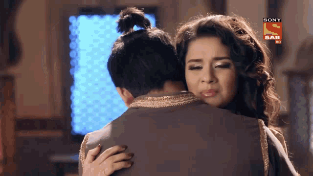 a woman is hugging a man with a sony sab logo on the bottom