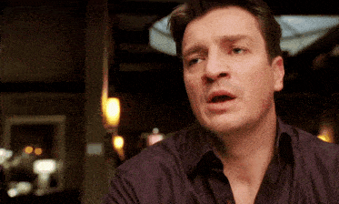 a man in a purple shirt is making a surprised face