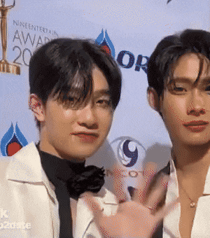 two men are standing in front of a wall that says awards