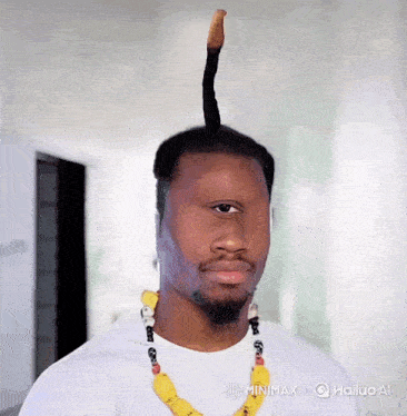 a man wearing a white shirt and a yellow necklace has a very long haircut