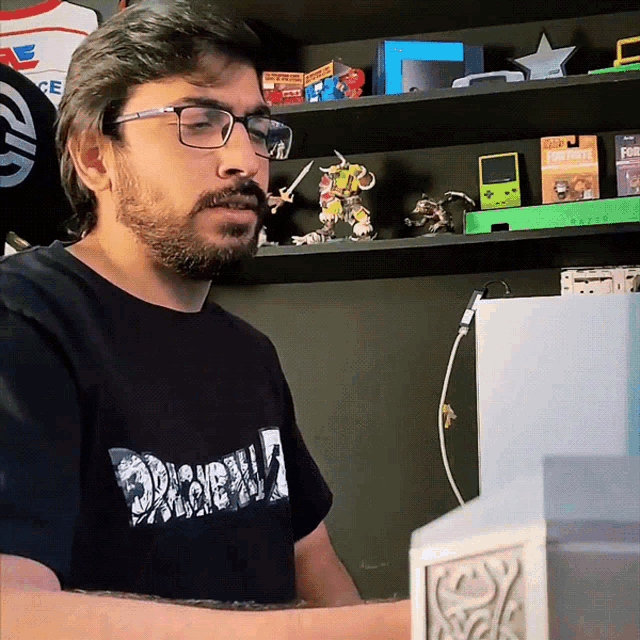a man wearing glasses and a black shirt with the word dragonball on it