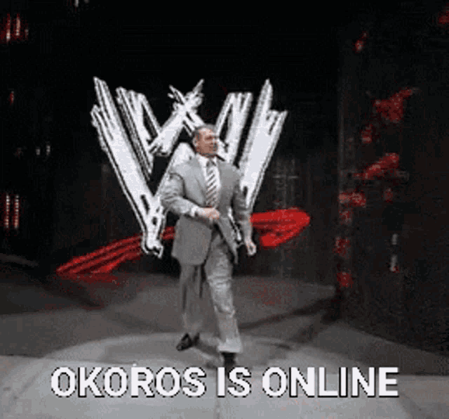 a man in a suit and tie is dancing on a stage in front of a wwe logo .