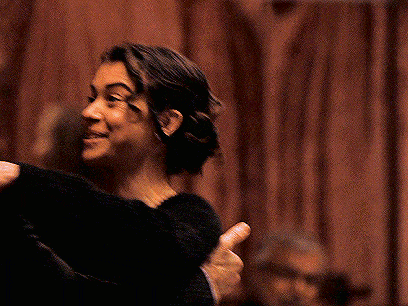 a man and a woman are hugging each other and the woman is smiling