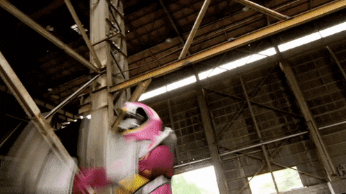 a person in a pink and yellow costume is standing in a building