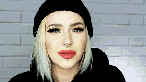 a woman wearing a black hat and red lipstick