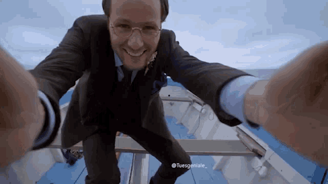 a man in a suit is taking a selfie on a boat with the hashtag tuesgeniusie