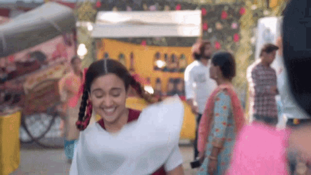 a woman in a white dress is dancing in a crowd of people .