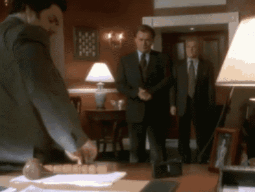 a man in a suit and tie is holding a hammer