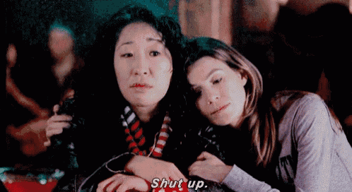 two women are sitting next to each other and one of them is holding the other 's hand .