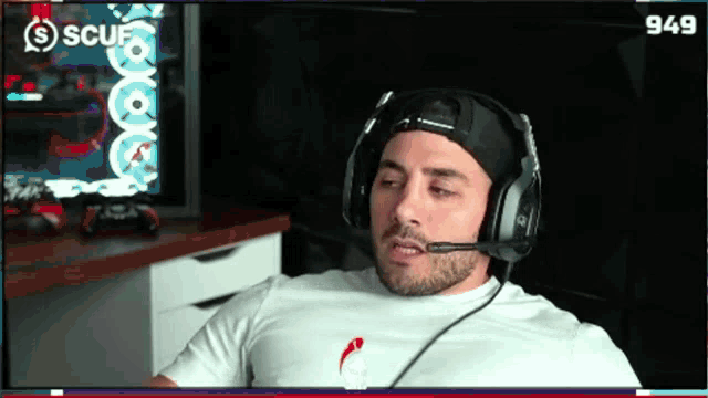 a man wearing headphones is sitting in front of a computer screen that says scuf on it