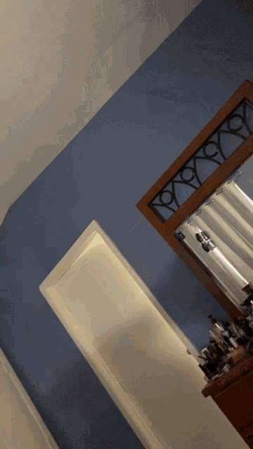 a bathroom with blue walls and a dresser with makeup on it