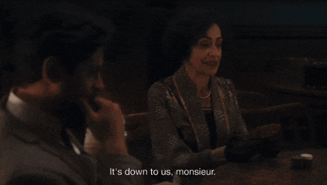 a man in a suit sits at a table with a woman and says it 's down to us