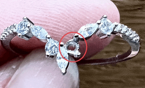 a close up of a diamond ring with a red circle around the center