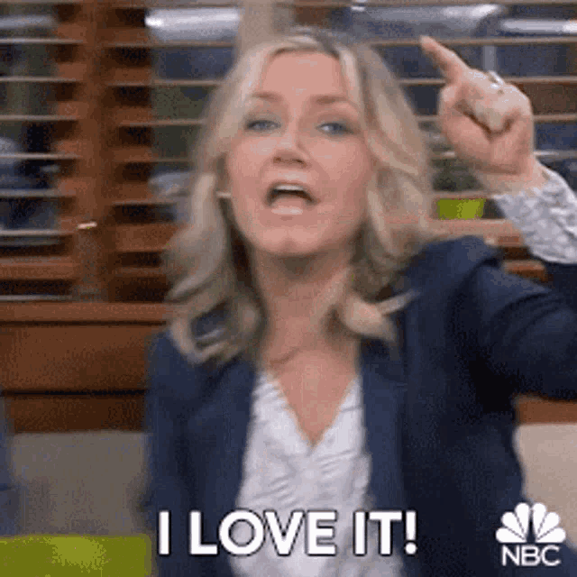 a woman is pointing her finger at the camera and saying i love it .
