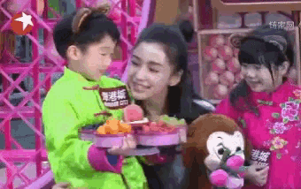 a girl holding a stuffed monkey and a boy holding a tray of food