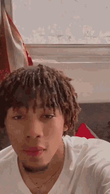 a young man with dreadlocks and a beard is taking a selfie .