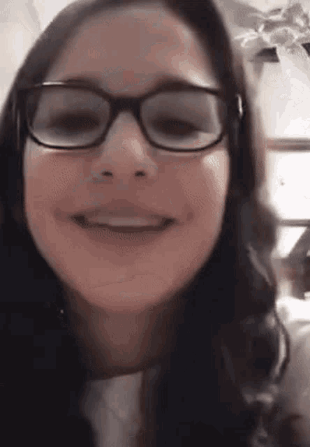 a close up of a girl wearing glasses smiling