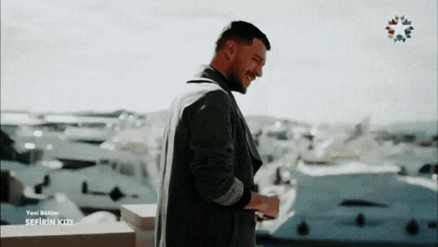 a man stands on a balcony with sefirin kizi written on the screen behind him