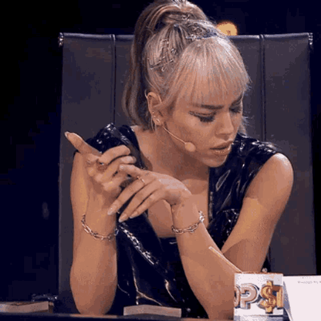 a woman sitting at a table with a box that says ps on it