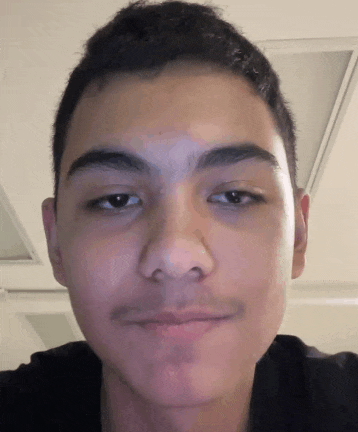 a close up of a young man 's face with a slight smile on his face