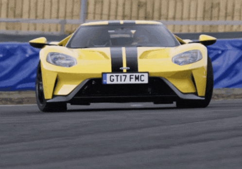 a yellow sports car with a license plate that says gti7 fmc