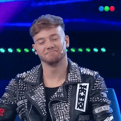 a man wearing a studded jacket with the word attention on the sleeve