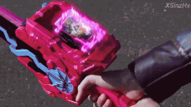 a person is holding a pink toy with a screen on it