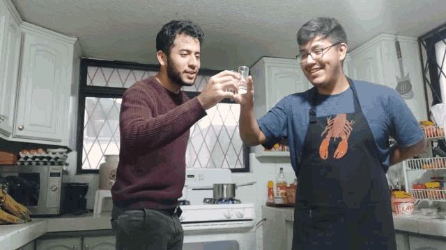 a man wearing a lobster apron holds up a glass