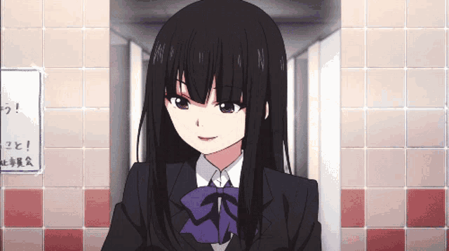 a girl with long black hair is standing in a hallway next to a sign that says ' n ' on it