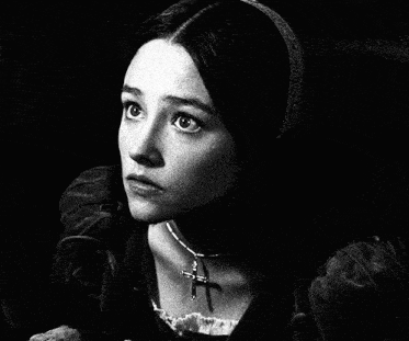 a black and white photo of a woman with a cross necklace around her neck