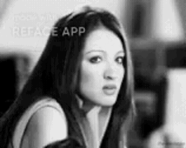 a black and white photo of a woman with long hair and a serious look on her face .